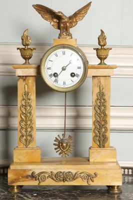 a gold clock with an eagle on top of it