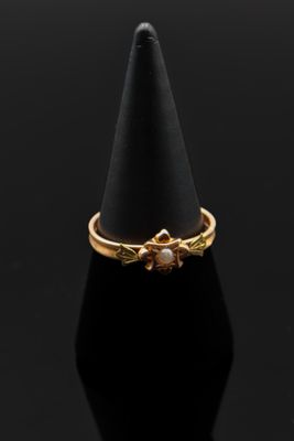 un gros plan d'une bague en or posée sur un cône noir