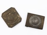 deux boutons anciens en métal et une pièce de monnaie posés sur une surface blanche