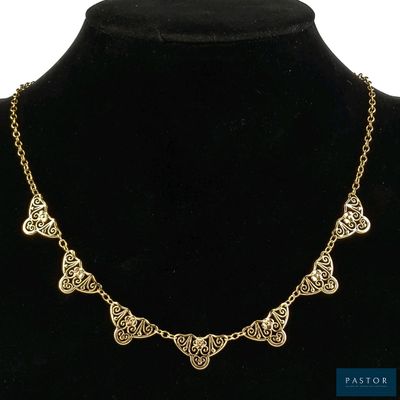 un collier en or autour du cou d'un mannequin, sur fond noir