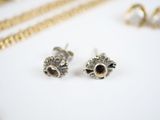 silver and gold earrings on a white surface with a gold chain