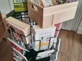 une pile de livres dans un panier posé par terre