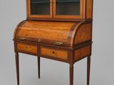 an antique writing desk with two drawers and a glass door