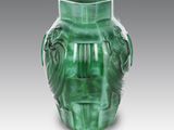 a green vase that is sitting on a table