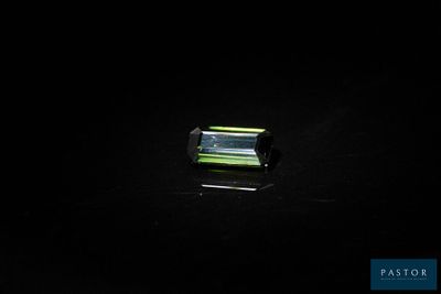 a green tourmaline gems on a black surface