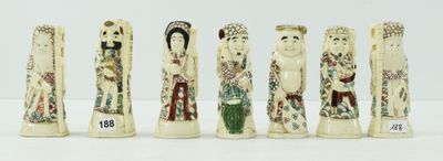 six figurines en ivoire sculpté sont alignées sur une surface blanche