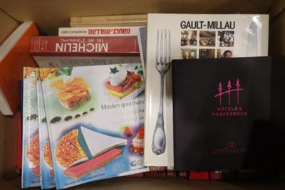 de nombreux livres de cuisine dans une boîte, avec une fourchette et un couteau