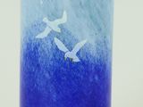 un vase en verre bleu orné de deux oiseaux