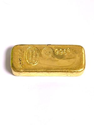 une barre d'or posée sur une surface blanche