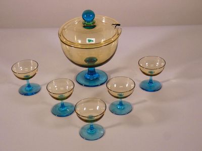 six verres et un saladier avec un couvercle posés sur une table