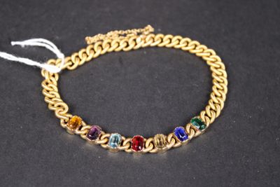 un gros plan sur un bracelet à chaîne en or orné de perles multicolores