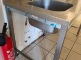 un évier en acier inoxydable et un extincteur dans la cuisine