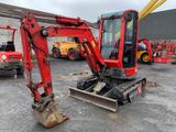 a red excavator that is parked in a parking lot