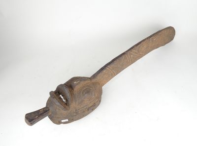 une vieille pince à tuyaux en bois avec un manche en bois, posée sur une surface blanche