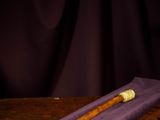 an old pipe sitting on top of a wooden table next to a purple cloth