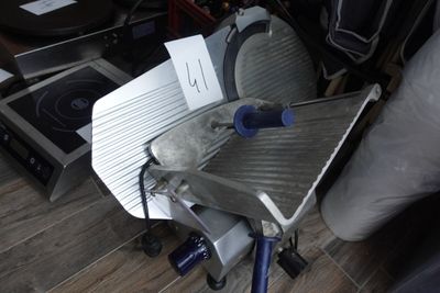 une grande trancheuse posée sur une table en métal