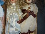 two dolls that are sitting in a box on a table