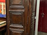 a tall wooden cabinet sitting in the corner of a room