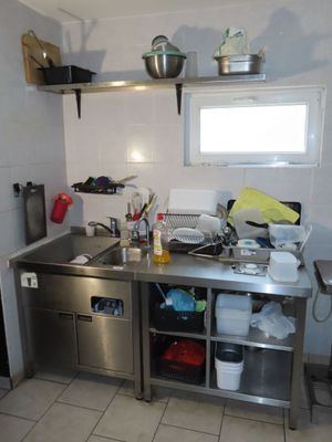 une cuisine équipée d'un évier, d'une cuisinière et d'un réfrigérateur