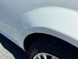 un gros plan sur le pneu avant d'une voiture présentant une bosse