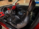 the interior of a small red car with the door open