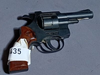 a toy gun with a tag on it sitting on a table