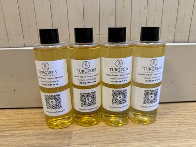 quatre flacons d'huile de bain Turroos posés sur une table