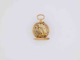 a close up of a gold pocket watch on a white surface