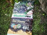 un sac de terre posé par terre près d'une clôture