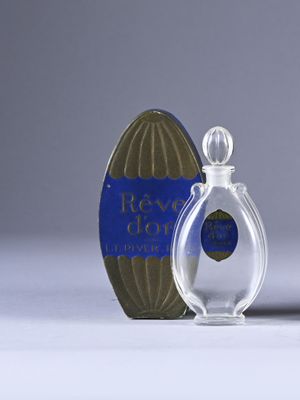 a small bottle of perfume next to a small box