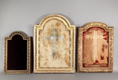 three antique picture frames are lined up against a gray wall