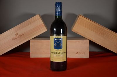 a bottle of wine sitting on a table next to two wooden boxes