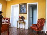 une chaise rouge dans une pièce où se trouve un tableau accroché au mur