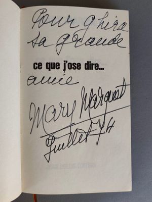 un livre ouvert, sur lequel on peut lire des mots, posé sur une table