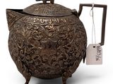 a large metal teapot with a tag on it