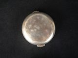 an old silver pill case sitting on a black surface