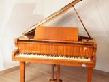 a grand piano sitting in a room with a white wall
