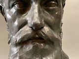 a statue of a man with a beard in a museum