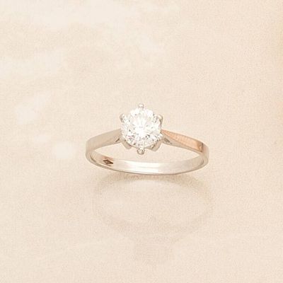 a ring with a diamond on it on a white surface