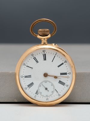 a gold pocket watch with roman numerals on it