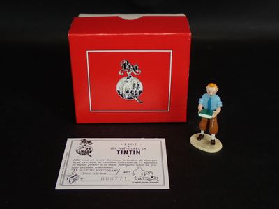 une petite figurine d'un homme debout à côté d'une boîte rouge