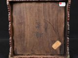 a close up of a picture of a wooden frame with a tag on it