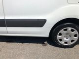 a small white van parked on the side of the road