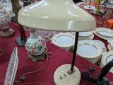 une table sur laquelle se trouvent une lampe et de nombreuses assiettes