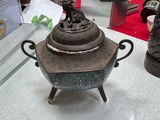 a silver teapot sitting on top of a table next to a pair of shoes