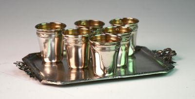 a silver tray with six shot glasses on it