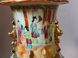 a vase with a painting on it sitting on a table
