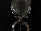 an antique silver pocket watch on a black background with reflection