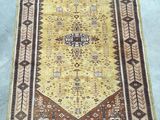 a yellow and brown rug sitting on top of a cement floor