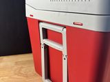 a red and white cooler sitting on a wooden table